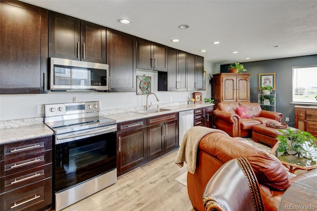 3308 County Road 19, Fort Lupton, CO 80621 - kitchen with appliances with stainless steel finishes, a sink, light wood-style floors, open floor plan, and recessed lighting