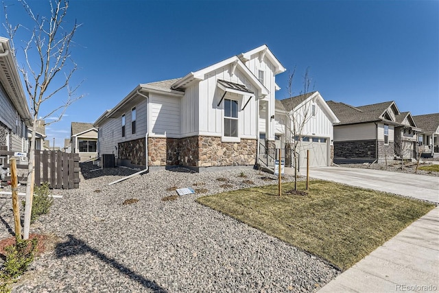 view of front of home featuring central air condition unit, a front yard, and a garage