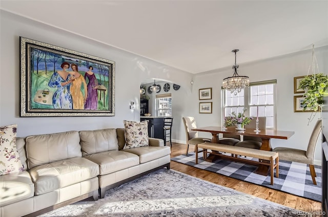 living room featuring an inviting chandelier, plenty of natural light, and hardwood / wood-style floors