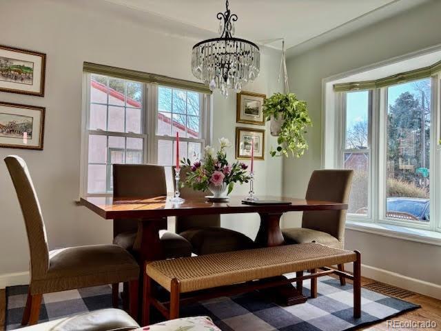 dining room with hardwood / wood-style flooring, a wealth of natural light, and a notable chandelier