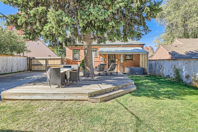 back of property featuring a wooden deck and a yard