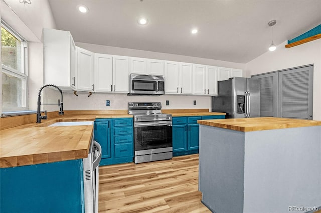 86 Will Stutley Dr, Divide, CO 80814 - kitchen featuring wooden counters, stainless steel appliances, blue cabinetry, a sink, and lofted ceiling