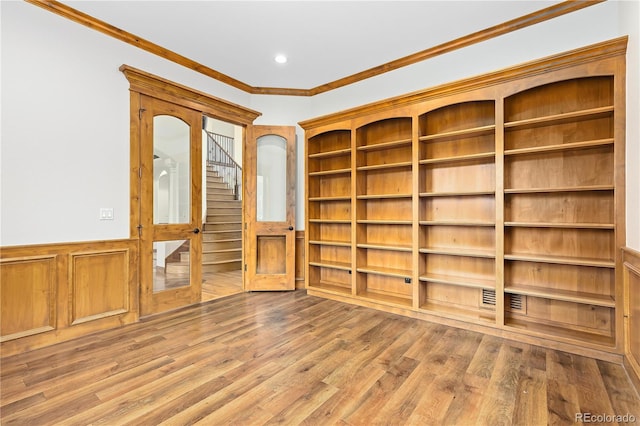 empty room featuring recessed lighting, wainscoting, crown molding, and wood finished floors