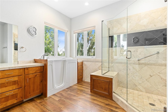 full bath featuring a shower stall, wood finished floors, and vanity