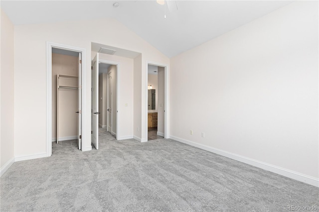 unfurnished bedroom with visible vents, baseboards, light colored carpet, vaulted ceiling, and a closet