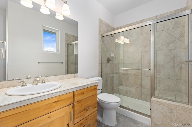 full bathroom featuring tile patterned flooring, a shower stall, toilet, and vanity