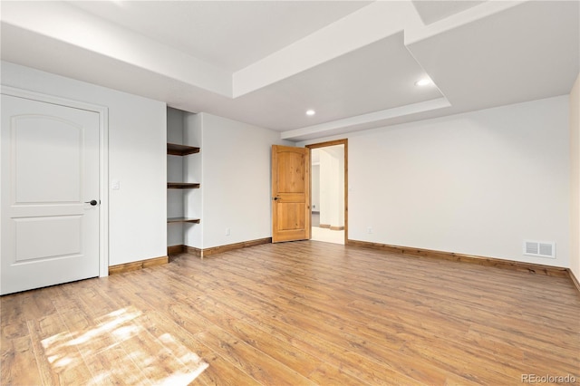 unfurnished bedroom featuring recessed lighting, visible vents, baseboards, light wood-style floors, and a raised ceiling