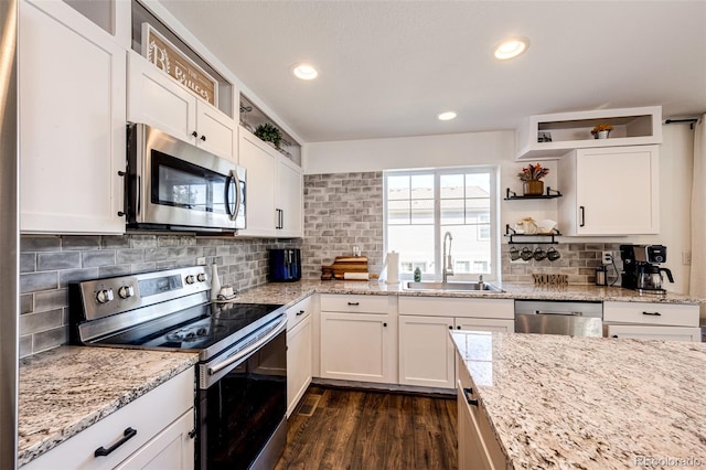 kitchen with white cabinetry, sink, dark wood-type flooring, backsplash, and appliances with stainless steel finishes