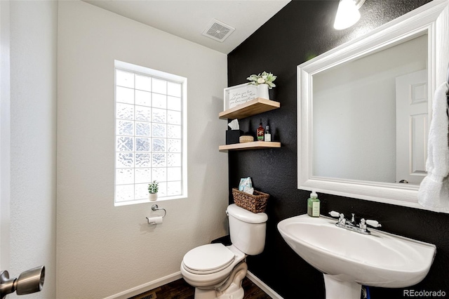 bathroom featuring wood-type flooring, toilet, and sink