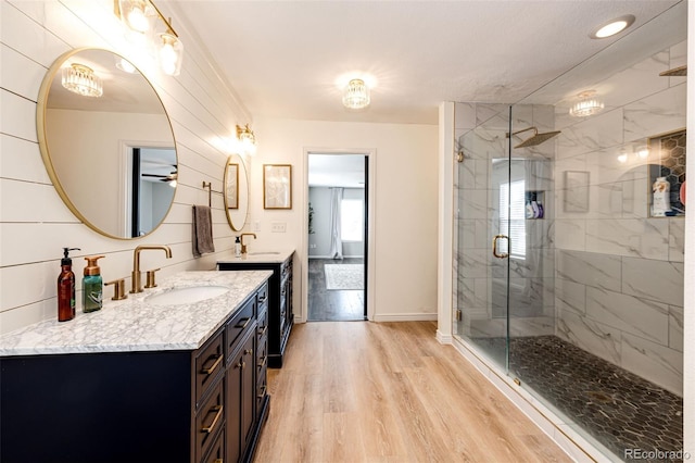 bathroom with wood-type flooring, vanity, and a shower with door