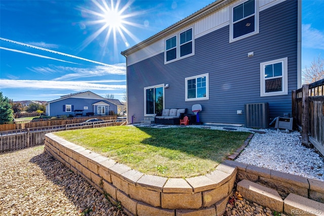 rear view of house featuring a yard and central AC unit