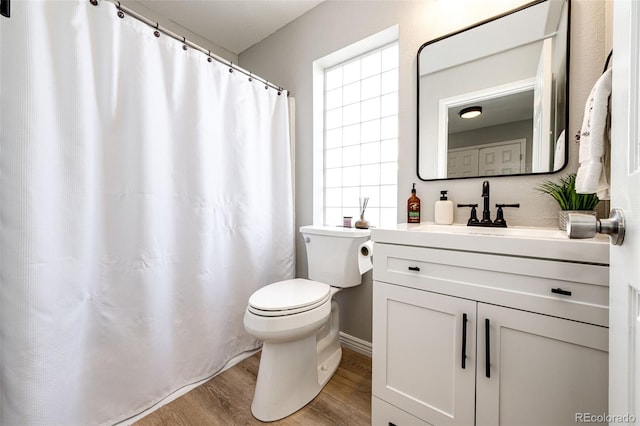 bathroom with vanity, a wealth of natural light, wood-type flooring, and toilet