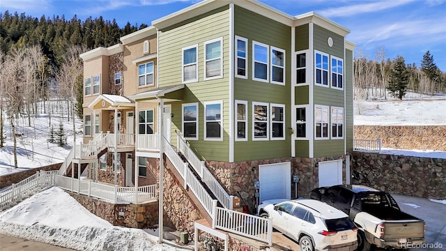 view of front of property with stone siding and stairway