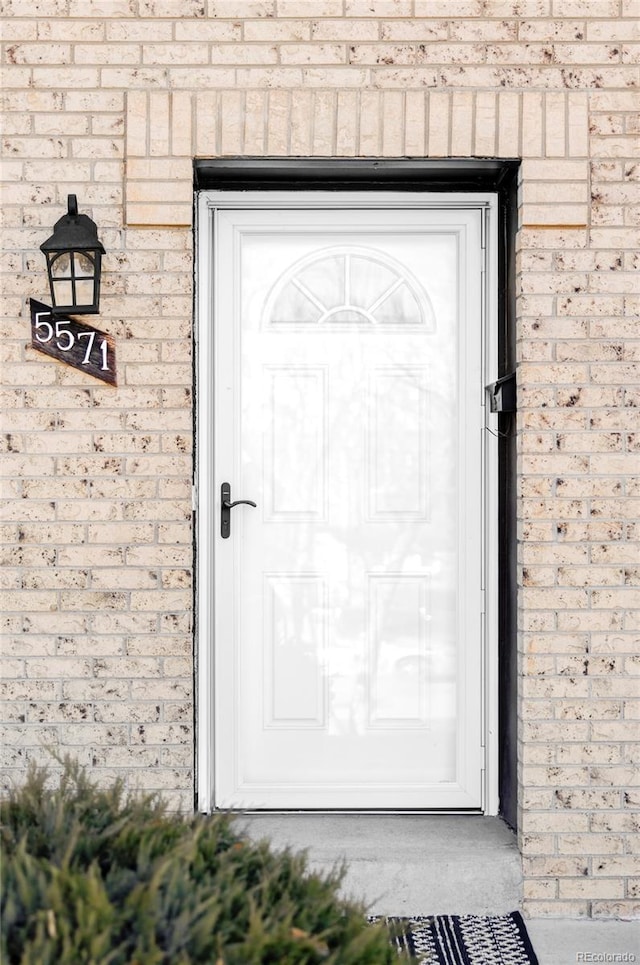 view of exterior entry with brick siding