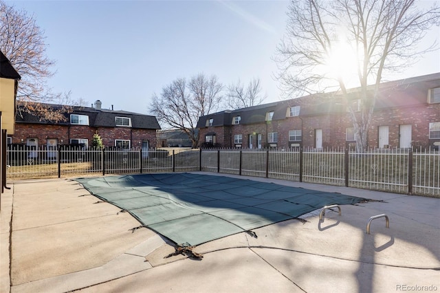 pool with a patio and fence