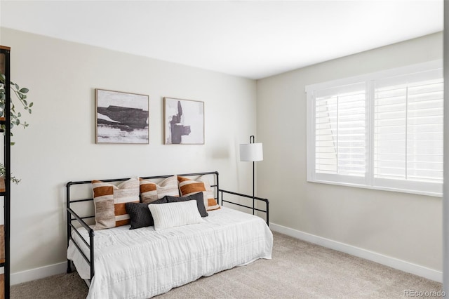 carpeted bedroom featuring baseboards