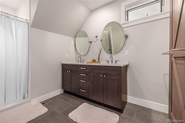 bathroom featuring tile patterned flooring, vanity, and lofted ceiling