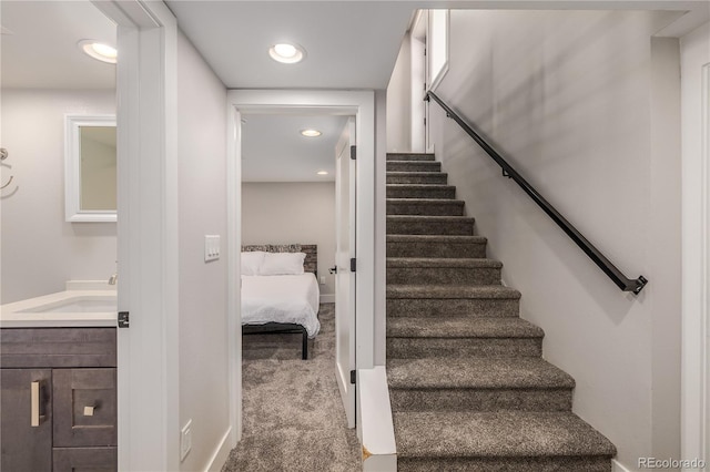 staircase with carpet and sink