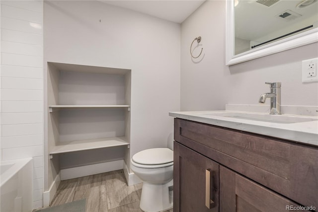 bathroom featuring hardwood / wood-style flooring, vanity, and toilet