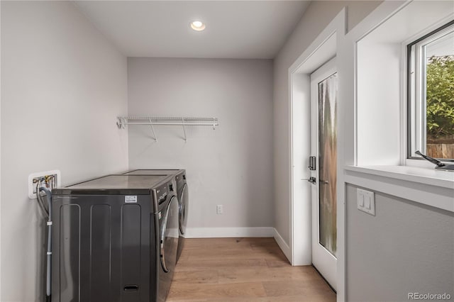 laundry room featuring light hardwood / wood-style flooring and washer and clothes dryer