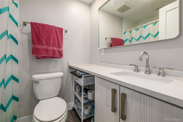 bathroom featuring toilet, vanity, and hardwood / wood-style flooring