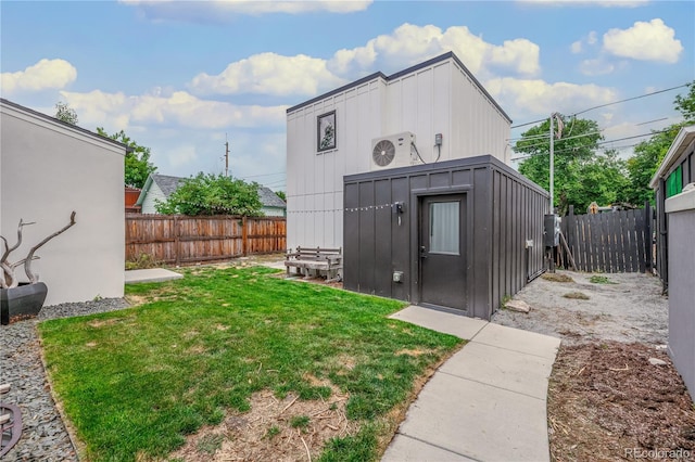 view of outbuilding with ac unit and a yard