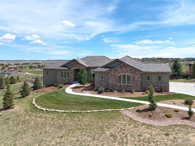 view of front of house with stone siding, stucco siding, and a front lawn
