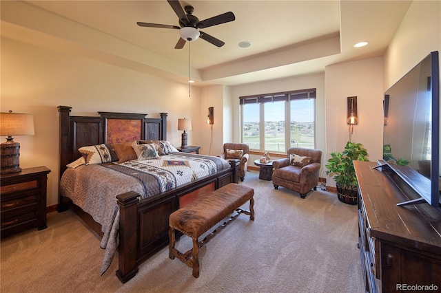 bedroom featuring light colored carpet, recessed lighting, a tray ceiling, and baseboards