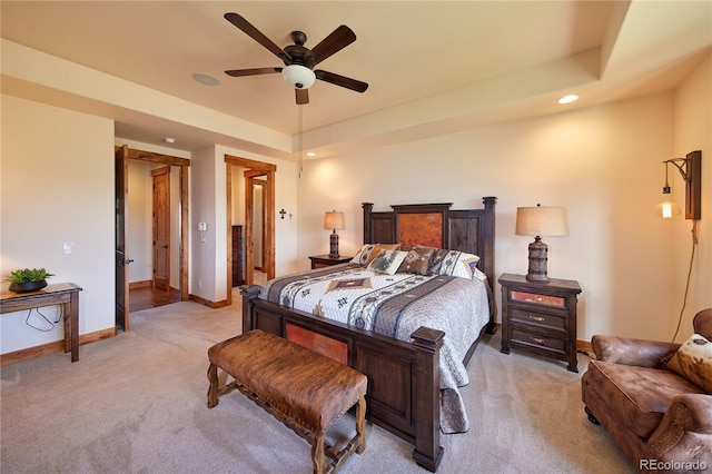 bedroom with light colored carpet, baseboards, recessed lighting, a ceiling fan, and a tray ceiling