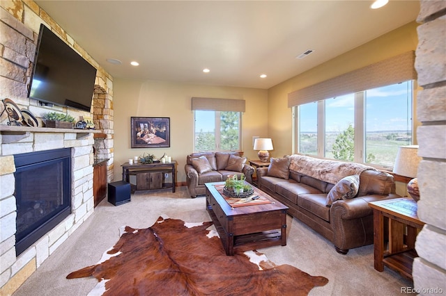 living room featuring light colored carpet, a stone fireplace, and recessed lighting