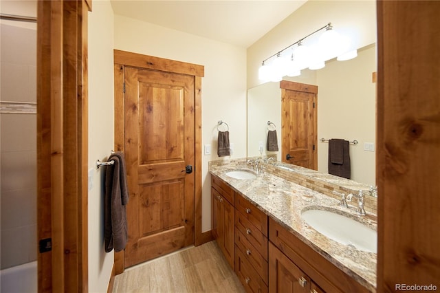 full bath with wood finished floors and double vanity