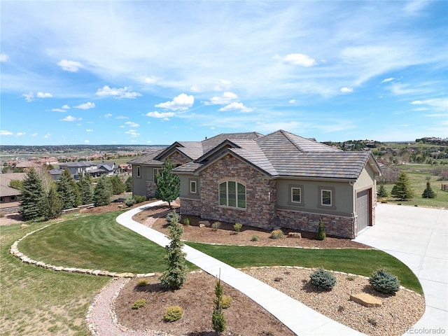 view of front of home with stone siding, driveway, stucco siding, a garage, and a front lawn