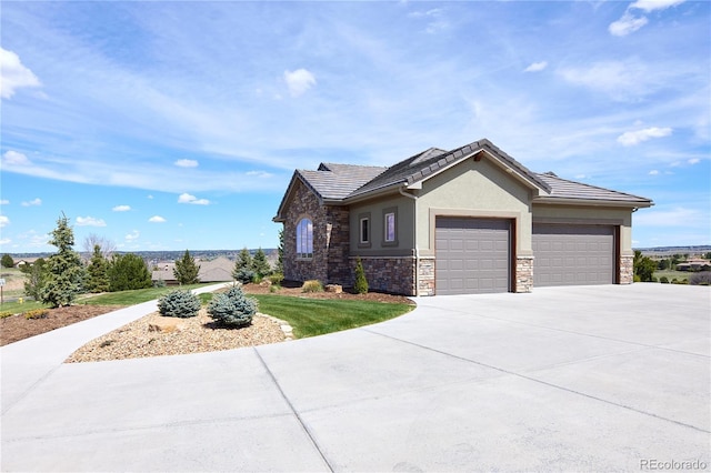view of front of house with a garage, stone siding, concrete driveway, stucco siding, and a tiled roof