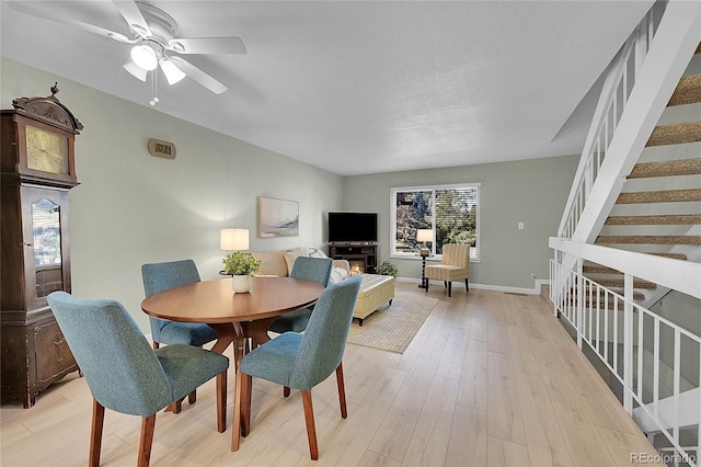 dining area featuring ceiling fan, a textured ceiling, and light wood-type flooring