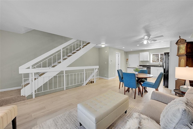 living room with ceiling fan and light hardwood / wood-style floors