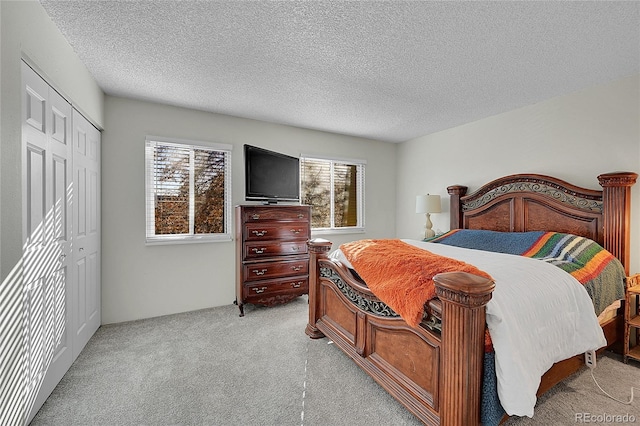 carpeted bedroom with a closet and a textured ceiling