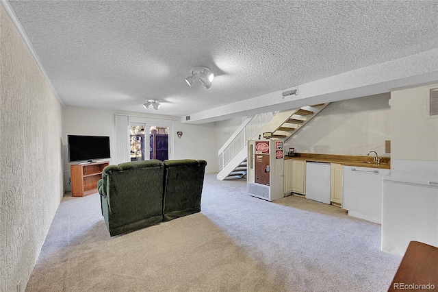 carpeted living room with sink and a textured ceiling