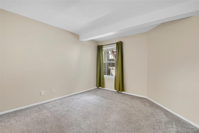 carpeted spare room with baseboards and a textured ceiling