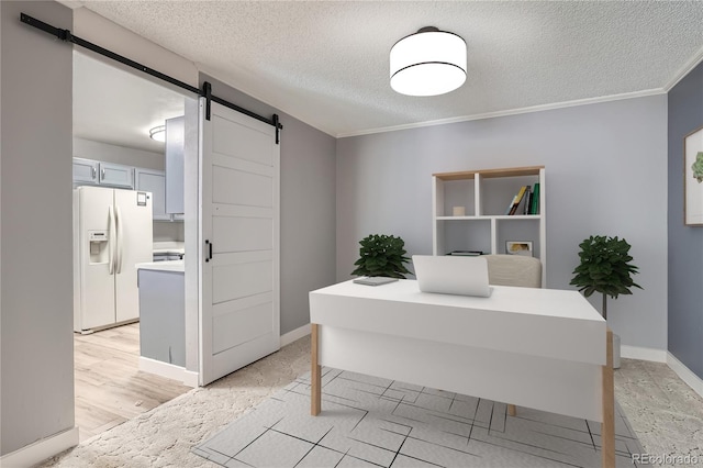 home office with light wood-type flooring, a textured ceiling, a barn door, and ornamental molding