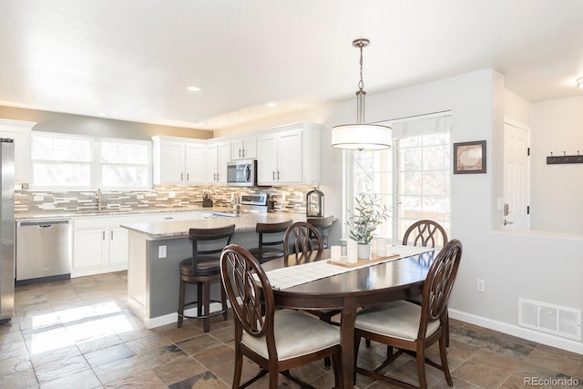 16102 Grebe Pl, Parker, CO 80134 - dining room featuring stone tile flooring, baseboards, and recessed lighting