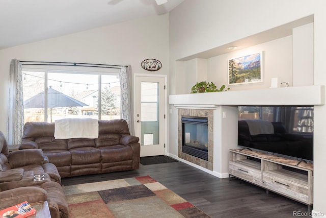16102 Grebe Pl, Parker, CO 80134 - living area featuring dark wood-type flooring, a tiled fireplace, high vaulted ceiling, ceiling fan, and baseboards