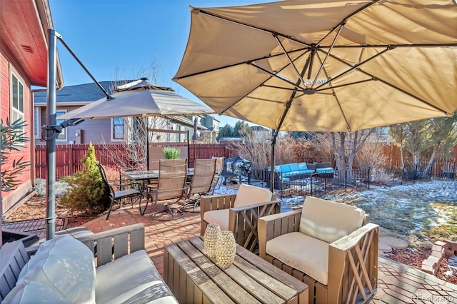 snow covered deck with an outdoor living space and a patio