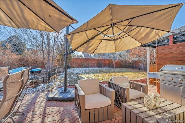 snow covered patio featuring area for grilling