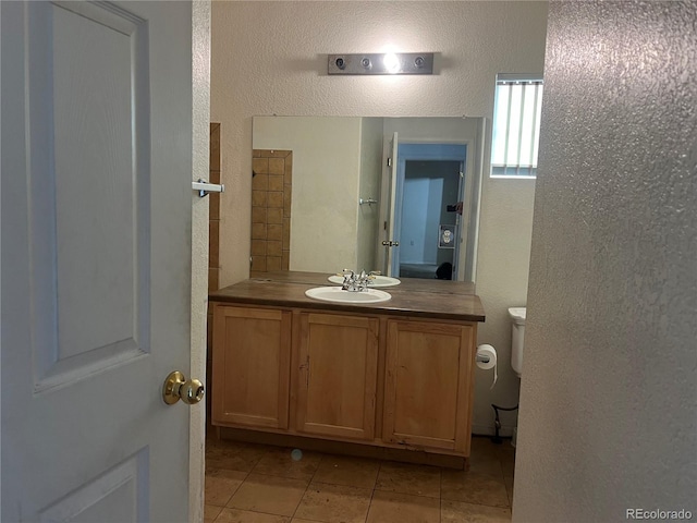 14400 Albrook Dr Unit 88, Denver, CO 80239 - bathroom with a textured wall, toilet, vanity, and tile patterned flooring