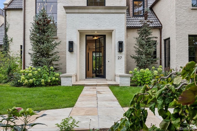 doorway to property featuring a yard