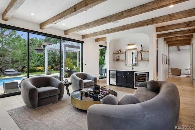 living room with wine cooler, beamed ceiling, light hardwood / wood-style floors, and indoor wet bar