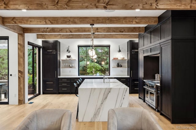 kitchen with beam ceiling, high end stainless steel range, decorative light fixtures, and light hardwood / wood-style flooring