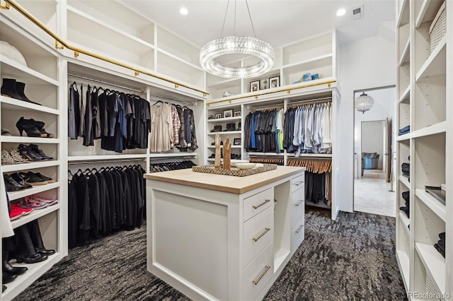 walk in closet featuring a notable chandelier