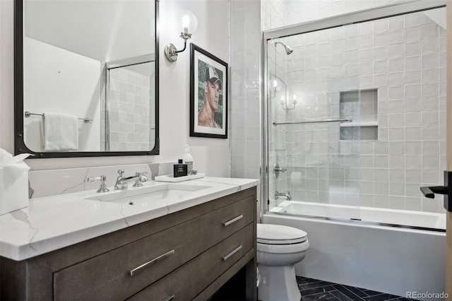 full bathroom featuring vanity, toilet, and bath / shower combo with glass door