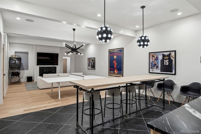 bar featuring pendant lighting, hardwood / wood-style flooring, and a high end fireplace